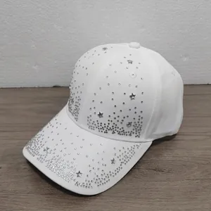 Close-up of a stylish white baseball cap decorated with sparkling rhinestone stars.