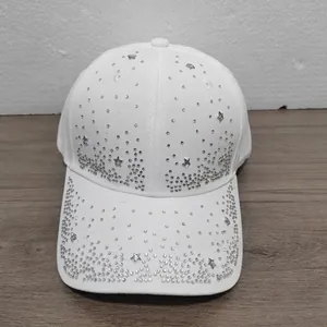 Close-up of star rhinestones and decorative studs on a white cotton baseball cap.