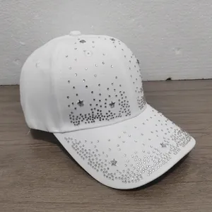 Detailed view of white baseball cap featuring sparkling silver star and dot rhinestones