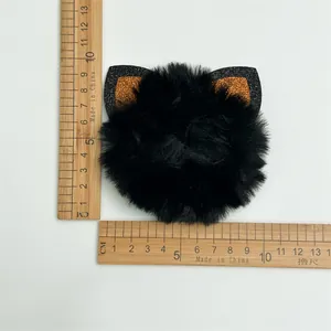Black fluffy cat ear hair scrunchie with orange glitter and size measurement reference
