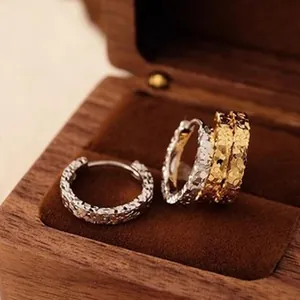 Detail view of a wooden jewelry packaging box with velvet lining and hoop earrings