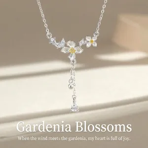 Close-up of elegant silver gardenia flower necklace with tassel and water drop pendant