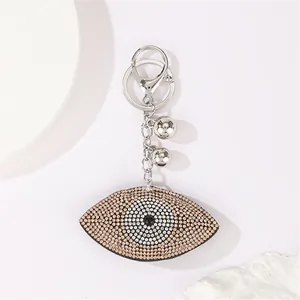 Detailed view of sparkling rhinestone evil eye keychain with silver bells decoration