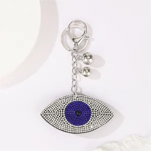 Close-up detail of a silver Turkish Evil Eye keychain pendant encrusted with blue and white crystals