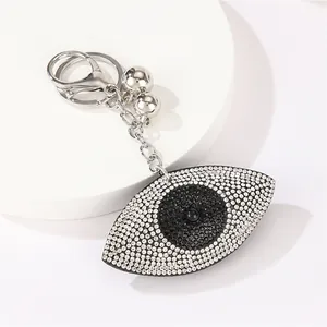Detail showing sparkling rhinestone evil eye keychain with silver chain and lobster clasp