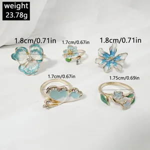 Detalle de set de anillos florales con esmalte azul y detalles de strass, 23.78g