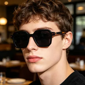 Stylish black square sunglasses worn by male model in a warm cafe lifestyle setting.