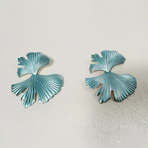 Gros plan détaillé de boucles d'oreilles bleu ginkgo aux textures radiales fines