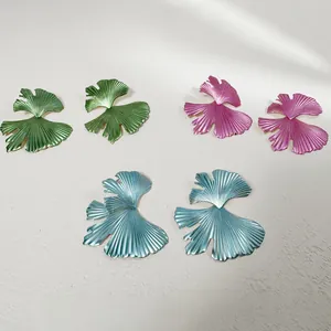 Vue détaillée de boucles d'oreilles feuilles en métal coloré : vert, rose et bleu ciel