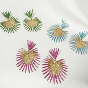 Vue détaillée de boucles d'oreilles feuilles dorées vintage en vert, bleu et violet.