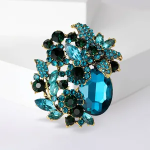 Exquisite close-up of a high-end vintage floral brooch with blue and green crystals