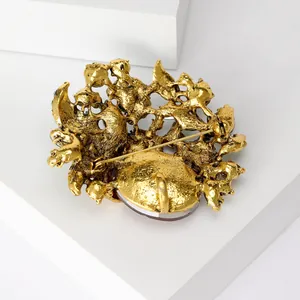 Detailed back view of vintage gold-tone brooch showing secure pin clasp and texture