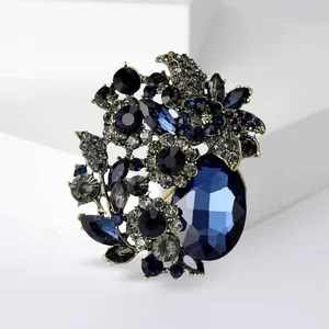 Detailed close-up of a vintage luxury blue crystal floral brooch with antique finish