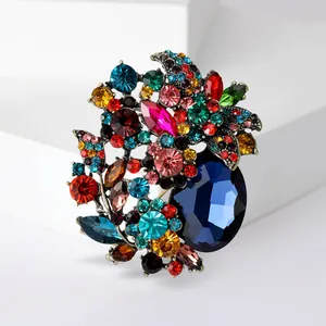 Macro view of vintage-style multi-colored crystal brooch with a large sapphire blue stone