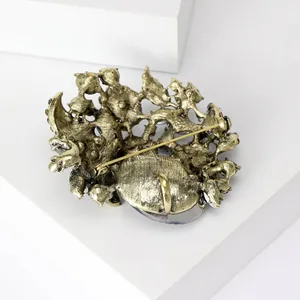 Detailed back view of a vintage gold glass brooch showing the secure pin closure.
