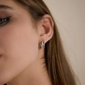 Detail view of elegant double-layered silver stainless steel hoop earrings with zircons