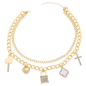 Detailed view of triple-layer gold chunky necklace with lock, heart, and cross charms.