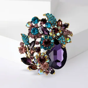 Close-up detail of a vintage style floral brooch with vibrant purple and blue crystals