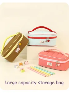 Detailed view of three macaron color-blocked cosmetic bags with cute heart pendants