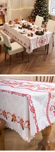 Detailed close-up of festive Christmas floral embroidery on a white lace tablecloth