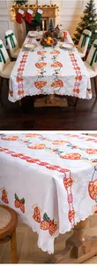 Detailed view of festive Christmas bell embroidery and lace edges on a white tablecloth