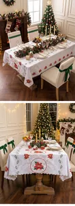 Detailed view of Christmas embroidered tablecloth with poinsettia patterns in a festive setting.