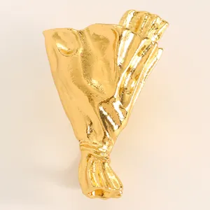 Close-up of a creative gold flower bouquet brooch with unique hammered metal texture.
