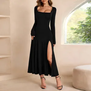 Robe longue noire élégante à col carré et manches longues avec fente latérale haute.
