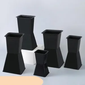 Close-up detail of multi-size black plastic square flower pots for floral arrangements