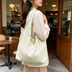 Asian model wearing a beige polka dot tote bag in a cozy cafe setting