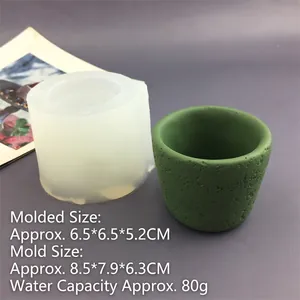 Detailed view of translucent silicone candle cup mold and textured green cement flower pot