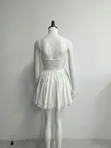 Back detail view of a white mini A-line dress featuring lace hem and sexy backless design