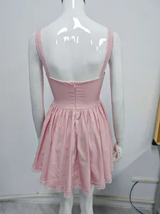 Back view of pink mini strap dress featuring lace trim and a deep open back with zipper.