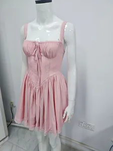 Detailed view of a pink lace-up suspender dress with lace trim on a white mannequin
