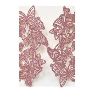 Detailaufnahme von rosa glitzernden, lasergeschnittenen Schmetterlings-Einladungskarten