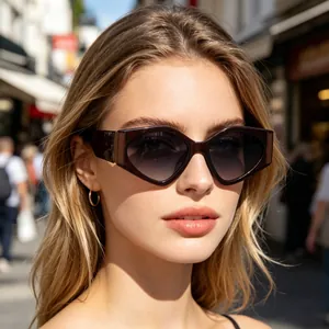 Close-up of stylish brown geometric cat-eye sunglasses on female model outdoors.