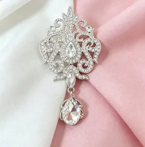 Detailed macro view of vintage silver brooch featuring teardrop crystals and pendant