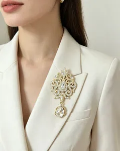 Close-up detail of a luxury vintage water drop crystal brooch pinned on a white blazer lapel