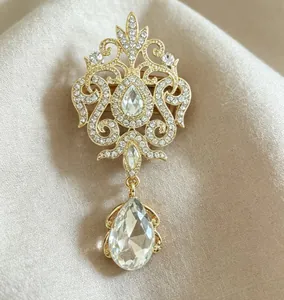 Detailed view of a vintage gold-toned teardrop crystal brooch with shiny rhinestones