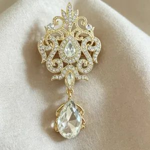 Luxurious vintage gold teardrop crystal brooch with elegant rhinestone details and pendant