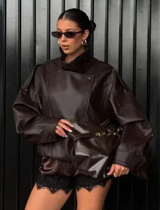 Close-up detail of vintage brown pebbled leather jacket featuring asymmetric high collar