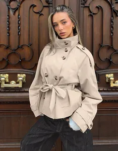Detailed view of an elegant khaki double-breasted short trench coat with waist belt