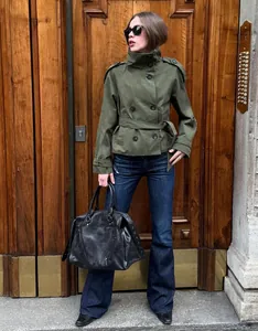 Detaile view of a women's olive green double-breasted belted short trench coat outfit