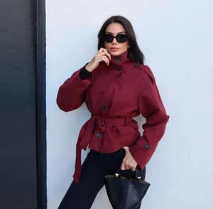 Detail of a burgundy short double-breasted trench coat with waist tie and belt