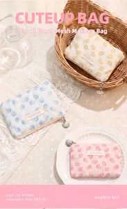 Close-up of three mesh floral makeup bags in soft pastel colors with shell zippers.