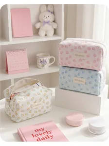 Pastel floral and fruit jacquard cosmetic bags arranged on a white vanity table