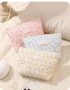 Detail showing three floral jacquard mesh makeup pouches in pink, blue, and beige colors