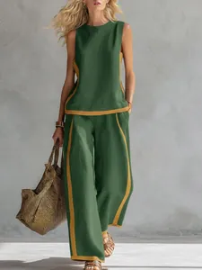 Elegante completo verde top senza maniche e pantaloni larghi con profili gialli chic