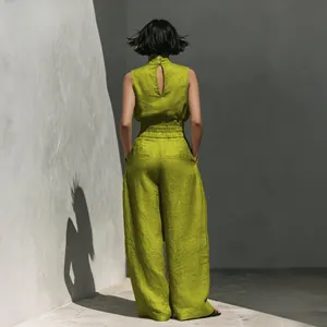 Back view of a lime green linen sleeveless top and wide-leg pants set in a minimalist setting