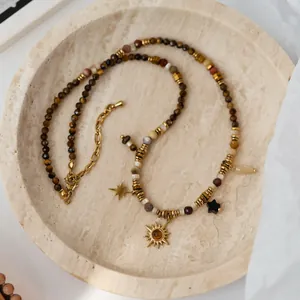 Detailed view of Bohemian Maillard style necklace with sunflower and star charms.